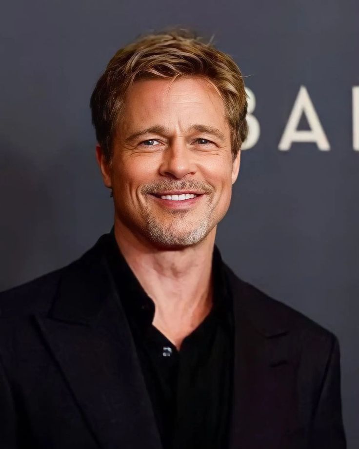 Bradley Pitt smiling in evening tailoring at an international film premiere